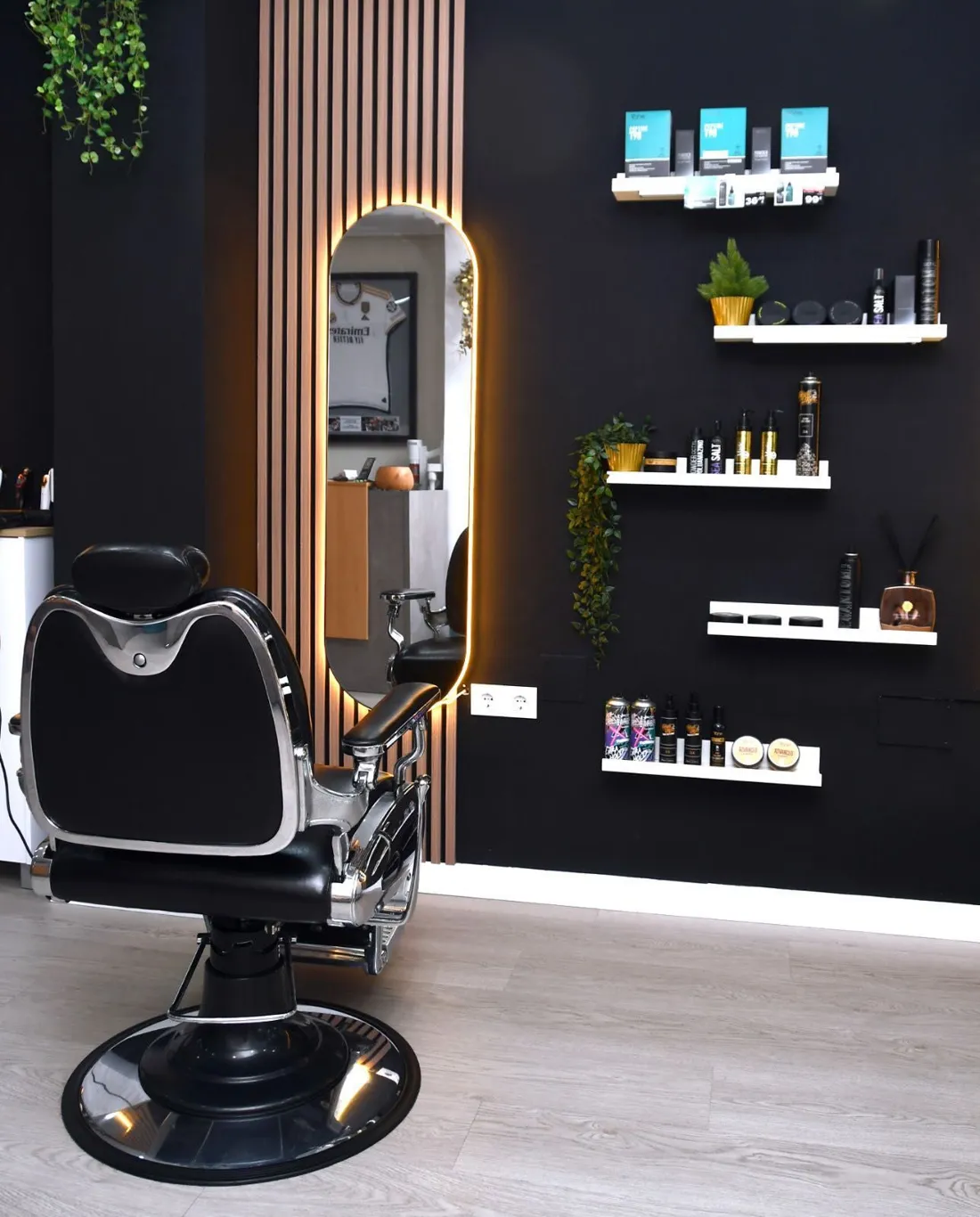 Interior de Paco Navarro Salon, peluquería y barbería masculina en Murcia: sillón de barbero frente al espejo de luz ámbar